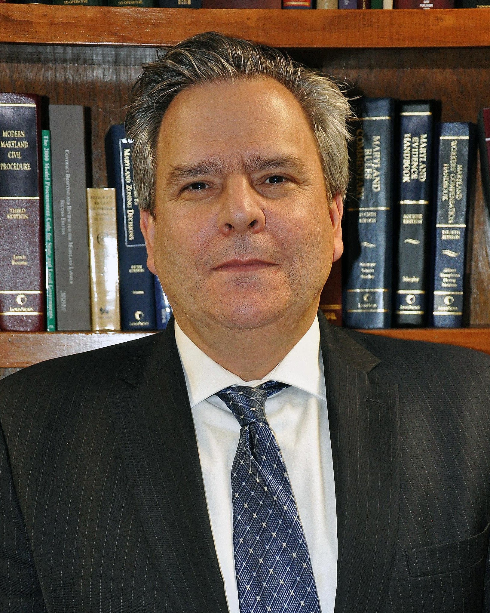 Headshot of County Administrator David Weiskopf standing in front of a bookshelf.